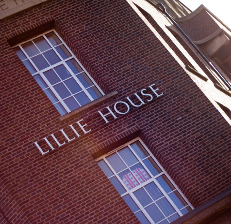 A photo of a large building with red bricks. Between two large vertical windows are the words Lillie House