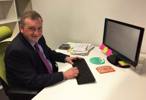 A new employee sat at his desk working on his computer.